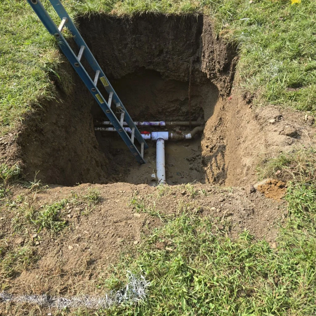 Excavated 4-inch PVC water line, tee and valve manifold at Antioch University